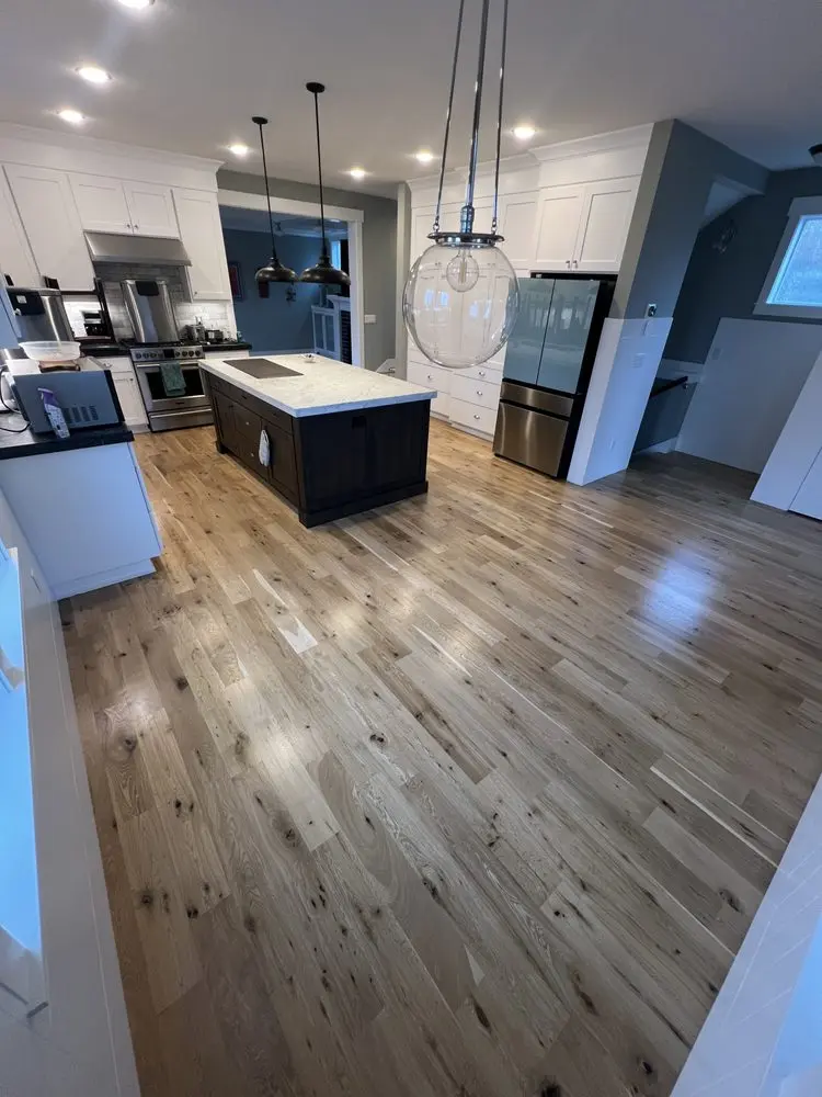 New flooring through an open kitchen by FED Builder