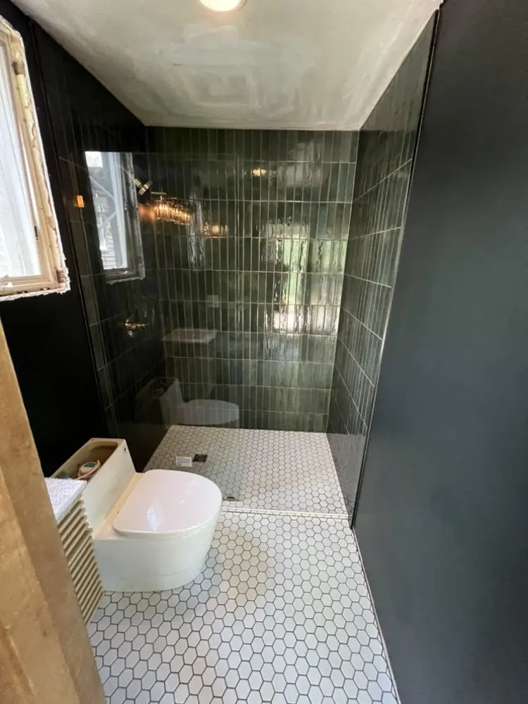 Bathroom with dark wall tile by FED Builder